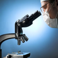 doctor looking through microscope